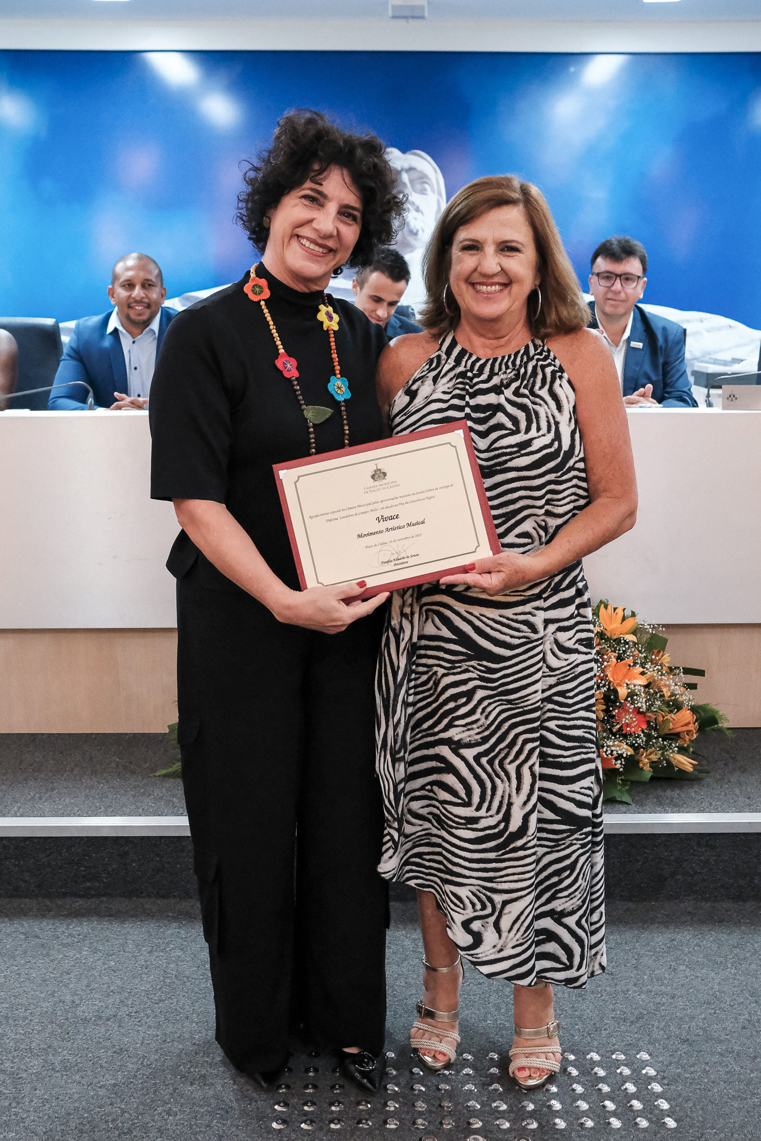 (à esq.) Raquel Mantovani, musicista e regente do Coral do Grupo Vivace, recebe um diploma em agradecimento pelas apresentações.